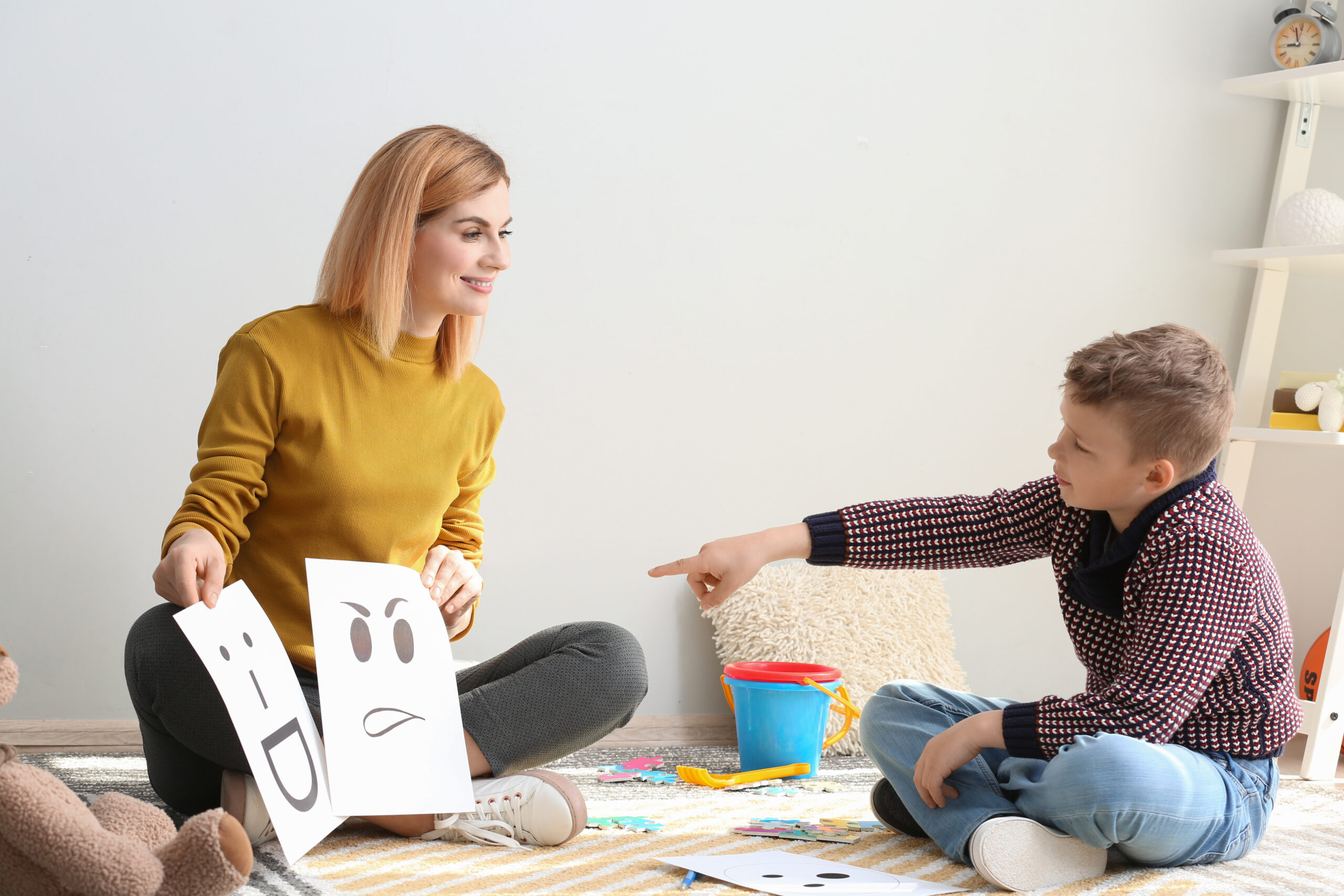 autism therapist shows flash cards while child gestures toward them