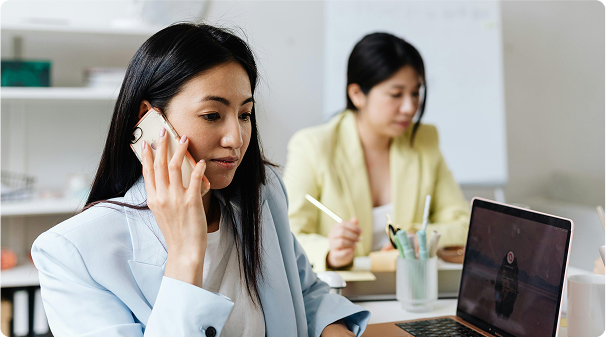 A woman holding a phone up to her ear in business attire