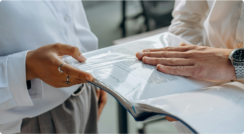 Two people reviewing a document in a plastic folder