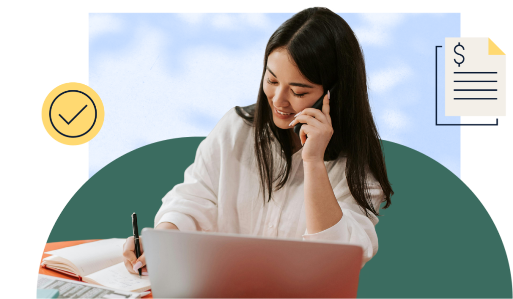 A woman smiling while on the phone and writing something down in a notebook